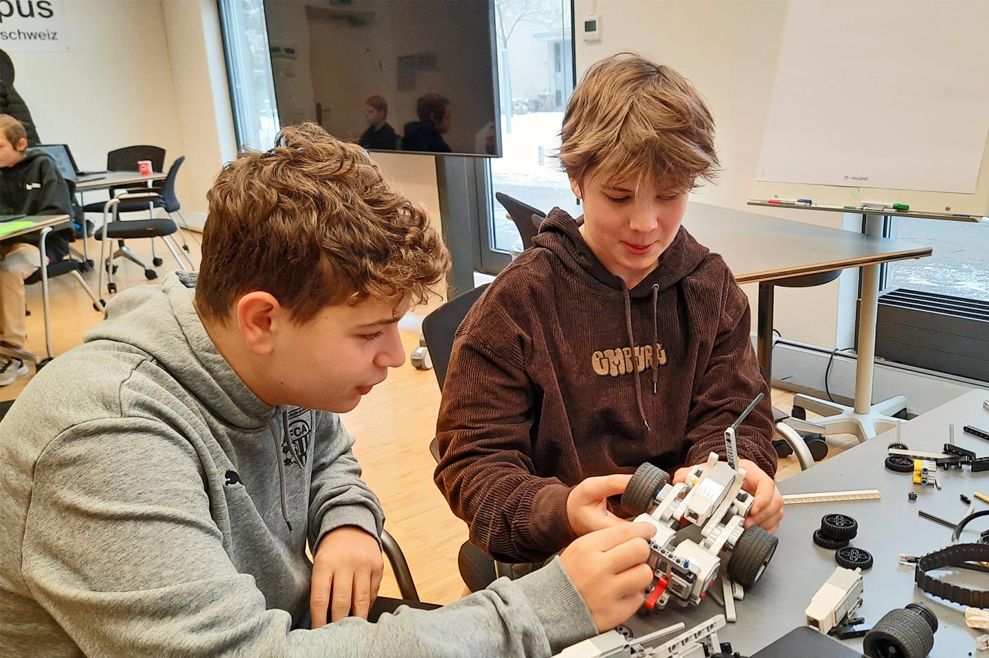 Diego Spina (links) und Dominik Walker diskutieren darüber, wie sie ihr Lego-Fahrzeug programmieren wollen.